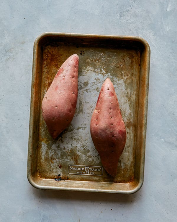 Two twice baked sweet potatoes on a baking sheet.