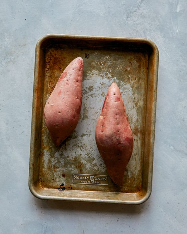 Two twice baked sweet potatoes on a baking sheet. 