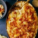 Cheesy Potatoes Casserole in a dish with a scoop taken out.