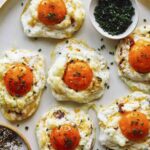 Cloud eggs on a platter with chives on the side.