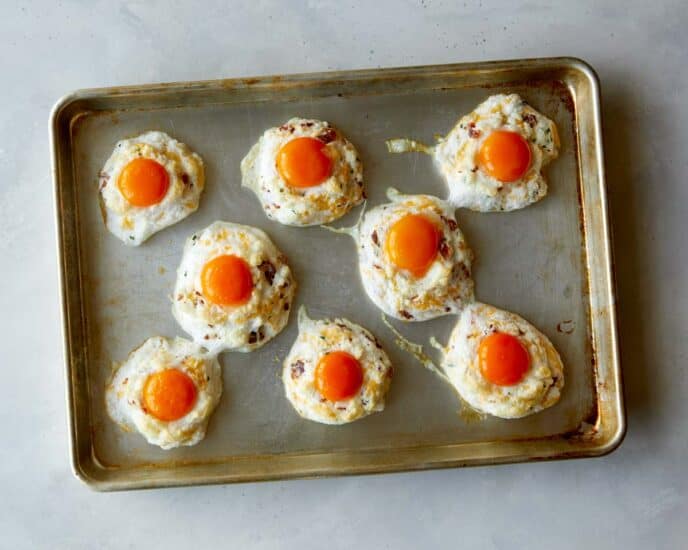 Egg clouds with egg yolks on a baking sheet.