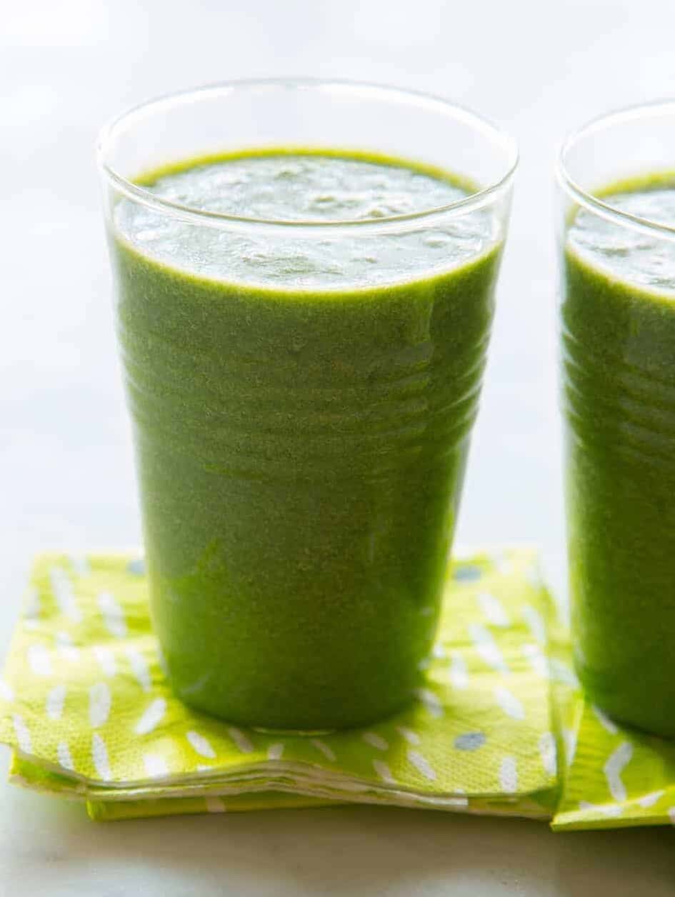 A close up of coconut kale smoothies with green printed paper napkins.