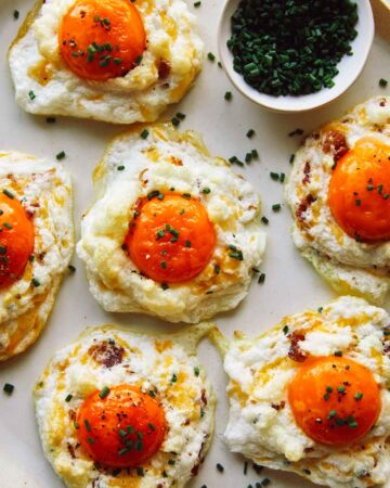 Cloud Eggs on a platter with slices chives.