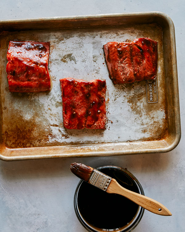 Teriyaki salmon with sauce being brushed on. 