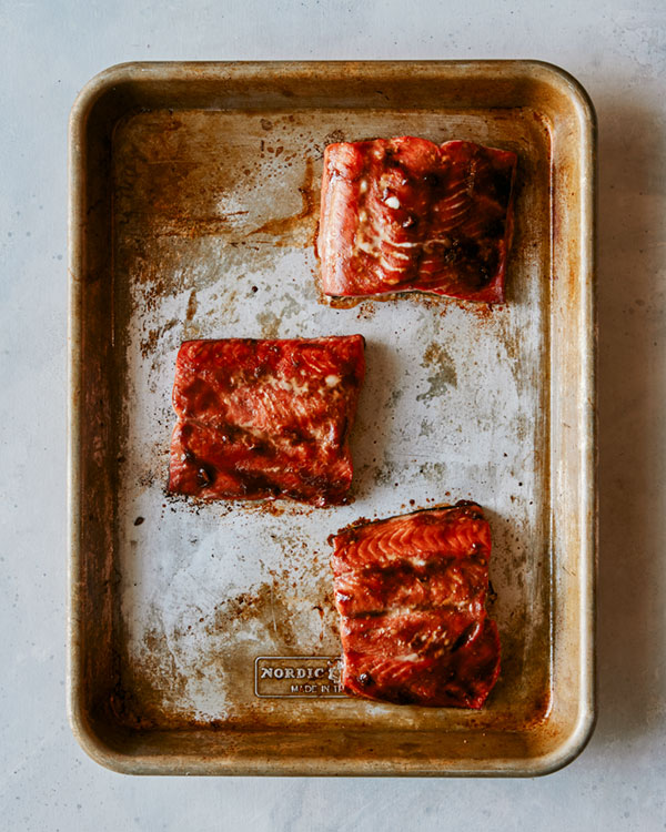 Teriyaki salmon on a baking sheet resting. 