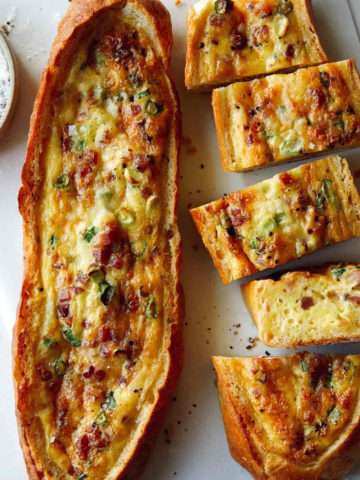 Baked egg boats on a surface being cut. 