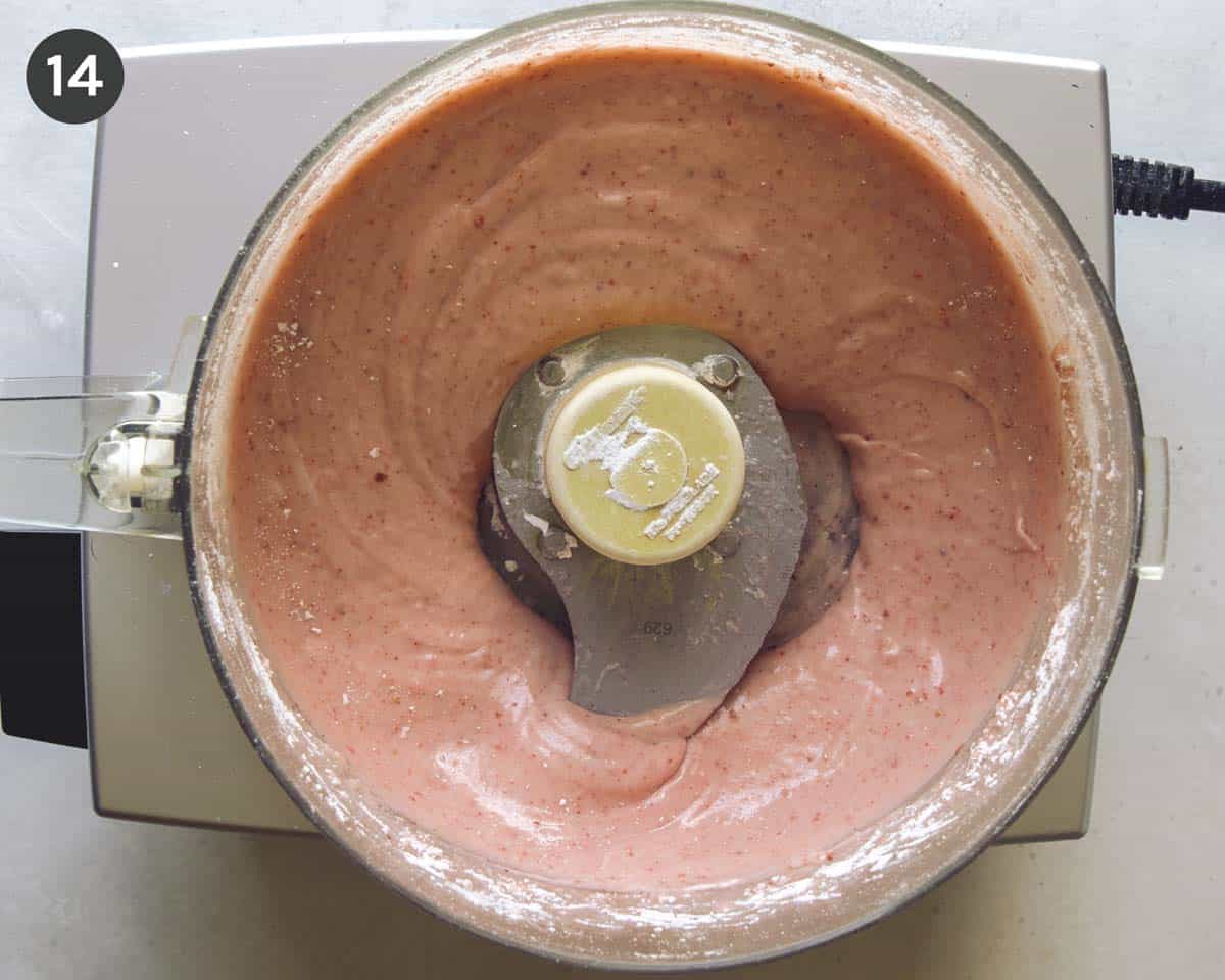 Strawberry frosting shown in the well of a food processor.