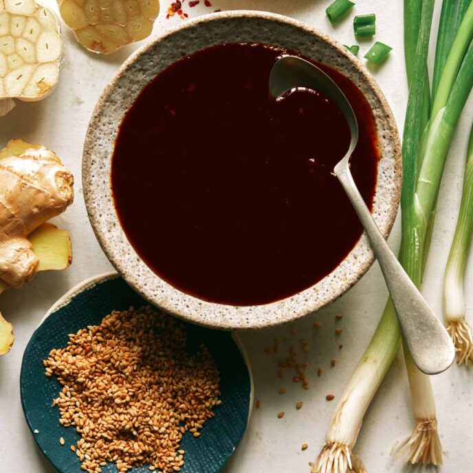 Teriyaki sauce in a bowl with ingredients around it. 