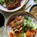 Teriyaki salmon recipe in two bowls with sesame seeds on the side.