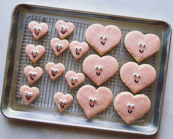 Valentines day cookies resting on a baking sheet. 