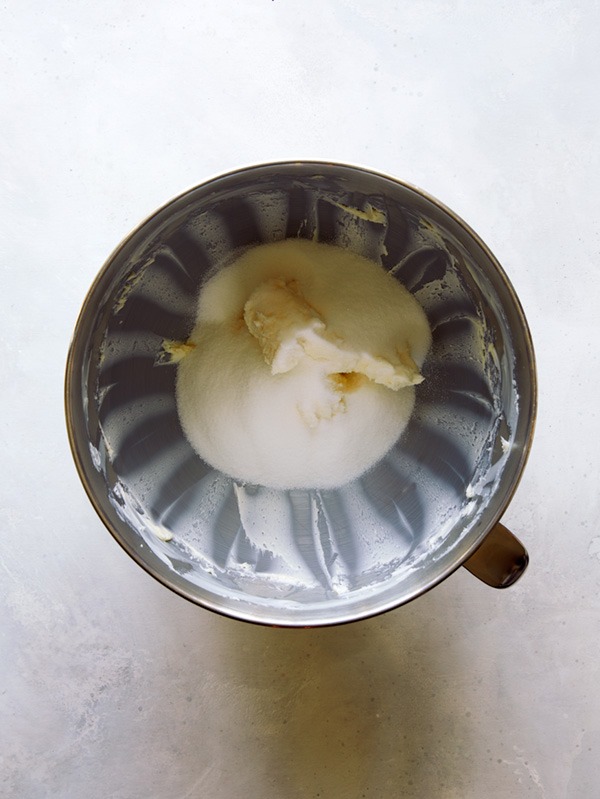 Butter and sugar being creamed in a stand mixer.