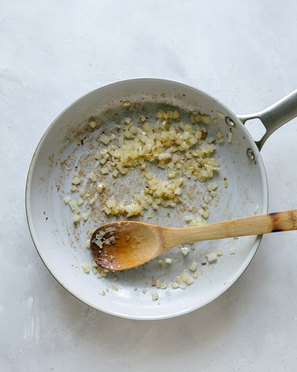 Onions and garlic cooking in a skillet. 