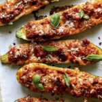 Zucchini boats on a platter with basil.