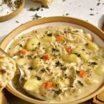 Chicken and gnocchi in a bowl with bread.