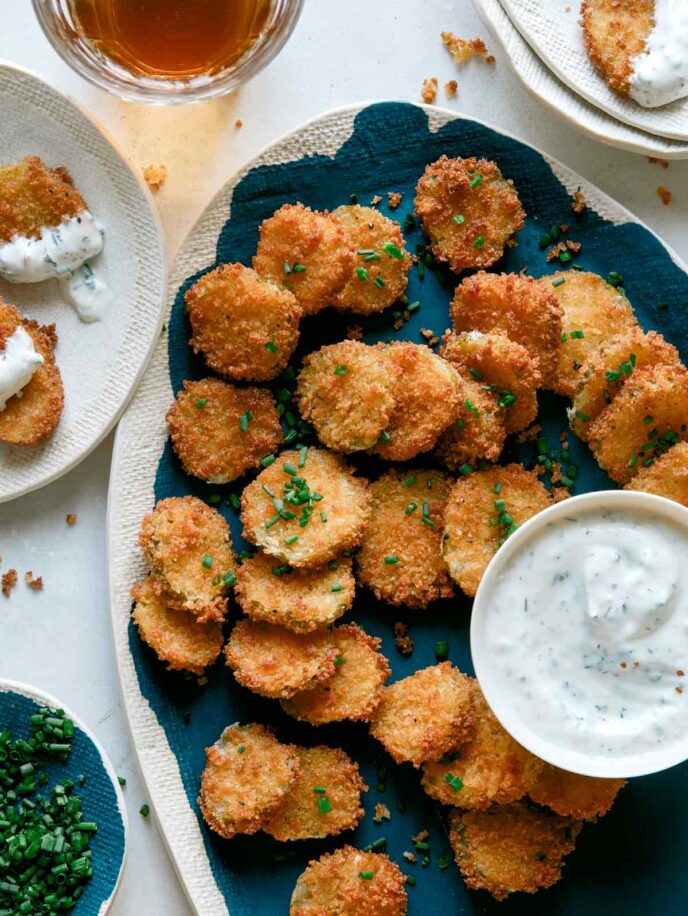 Fried pickle chips on a platter with beer on the side.