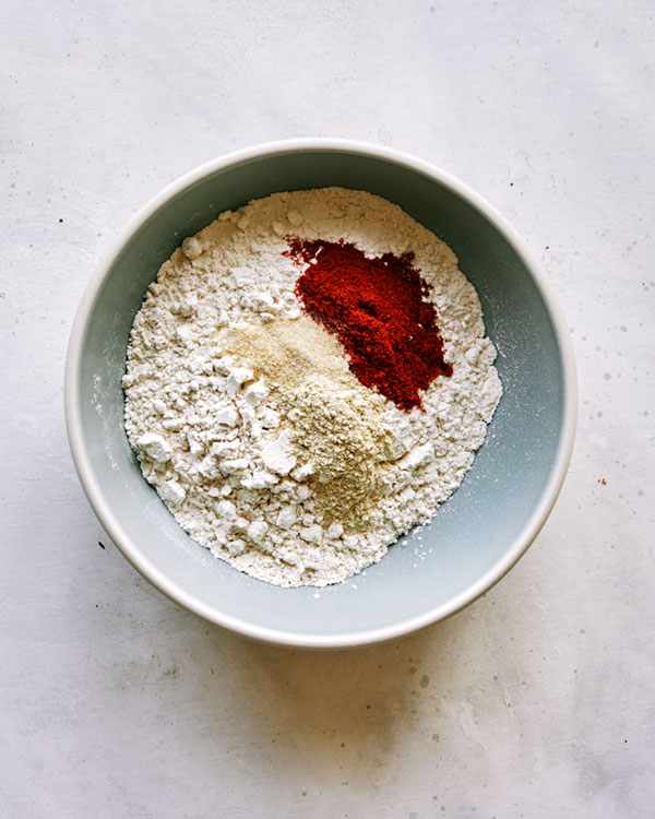 Flour and seasoning in a bowl for air fryer chicken tenders.