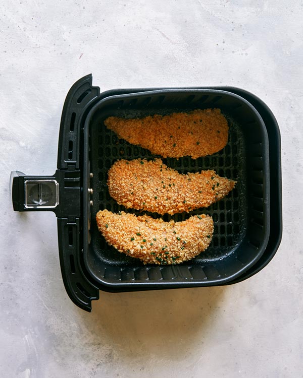 Air fryer chicken tenders in the basket ready to be cooked.