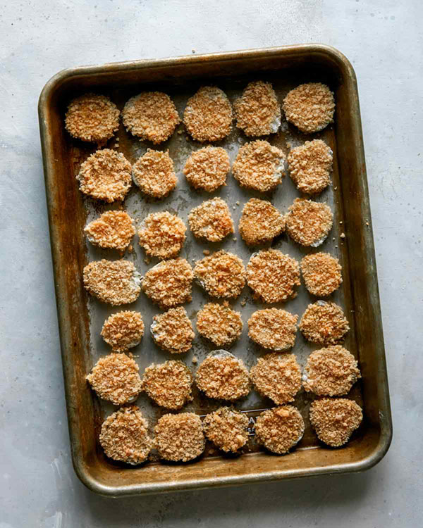 Pickle chips on a baking sheet pre fried.
