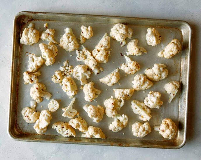 Cauliflower florets on a baking sheet. 