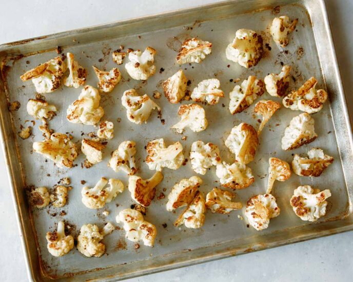 Roasted cauliflower florets on a baking sheet.
