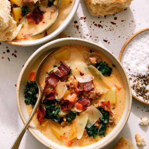 Zuppa toscana in two bowls with bread on the side.