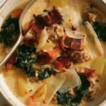 Zuppa Toscana in a bowl with bread in the background.