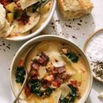Zuppa Toscana in a bowl with bread in the background.