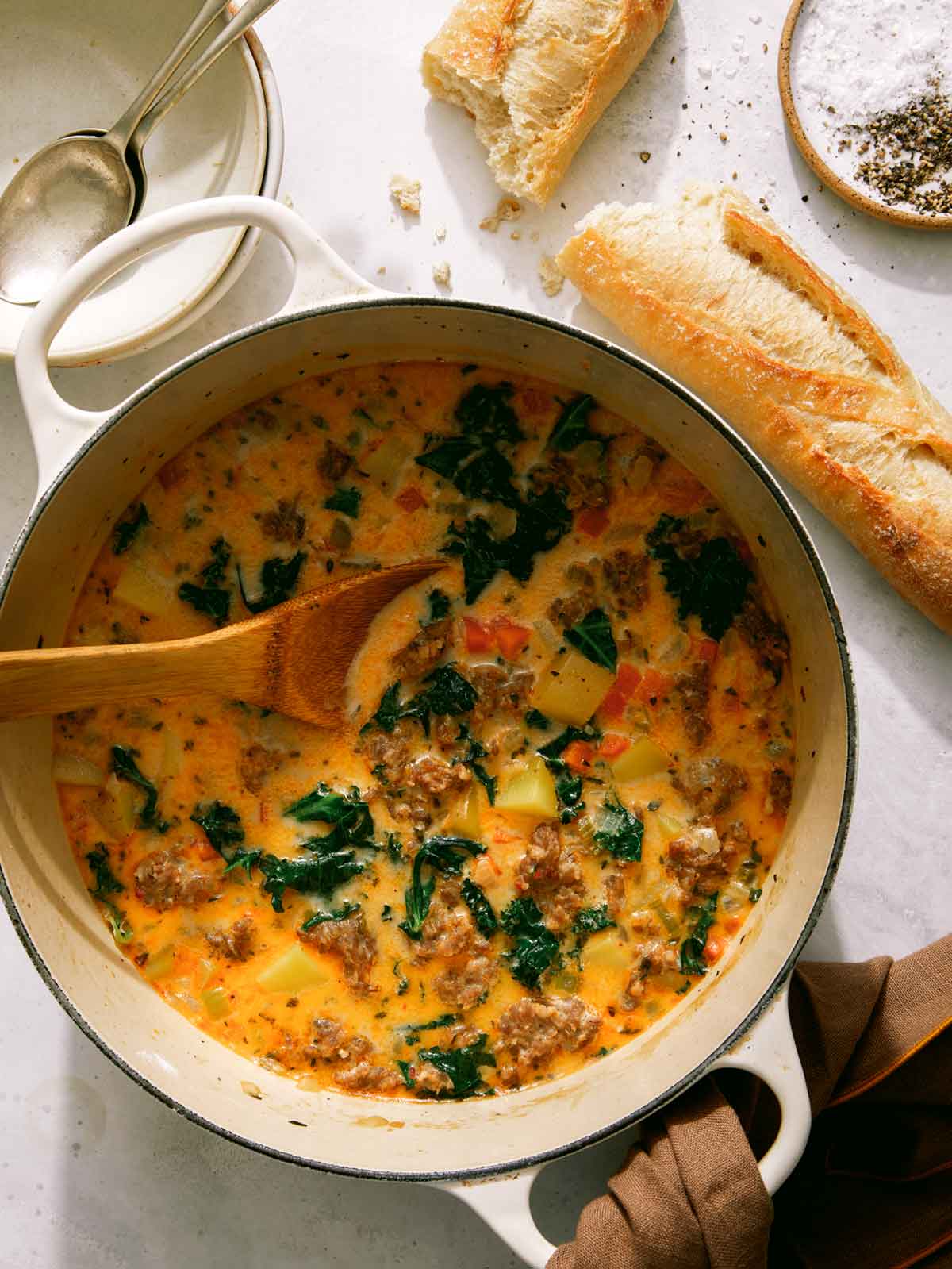 Zuppa Toscana in a pot with bread on the side.