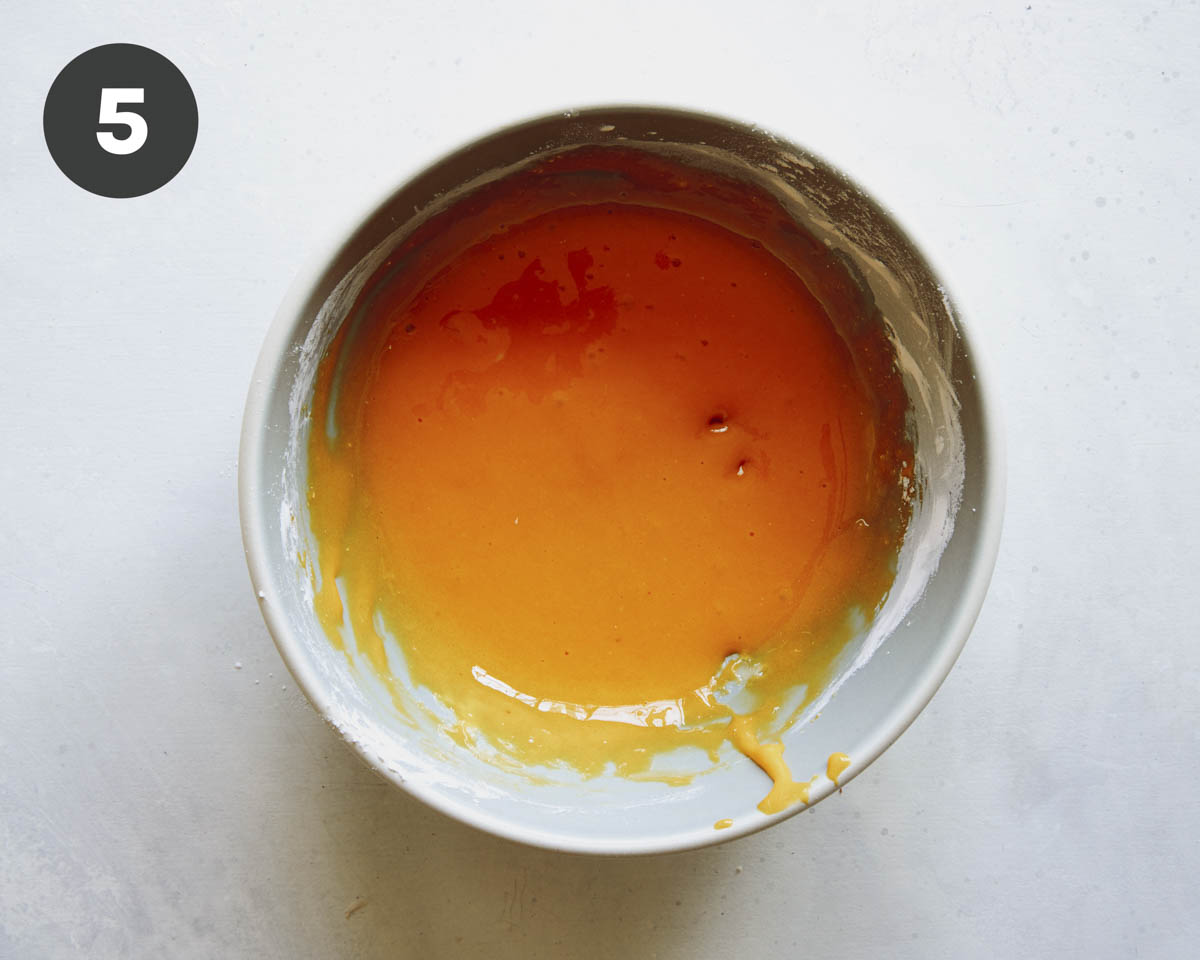 Egg yolks and cornstarch mixed together in a bowl to make pudding. 