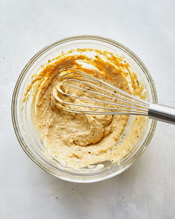 Chickpea dressing ingredients whisked together in a bowl.