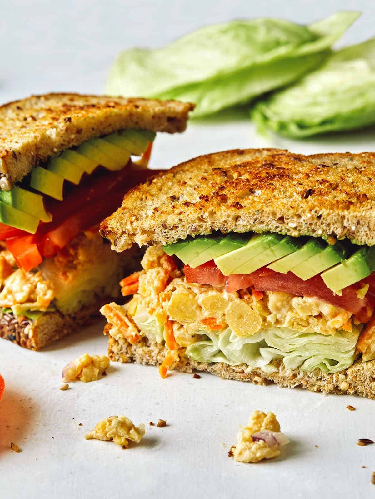 Close up on a chickpea salad sandwich cut in half. 