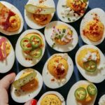 Deviled eggs being taken off a platter.