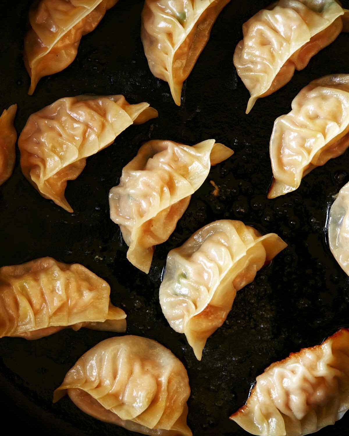 potstickers cooking in a skillet. 