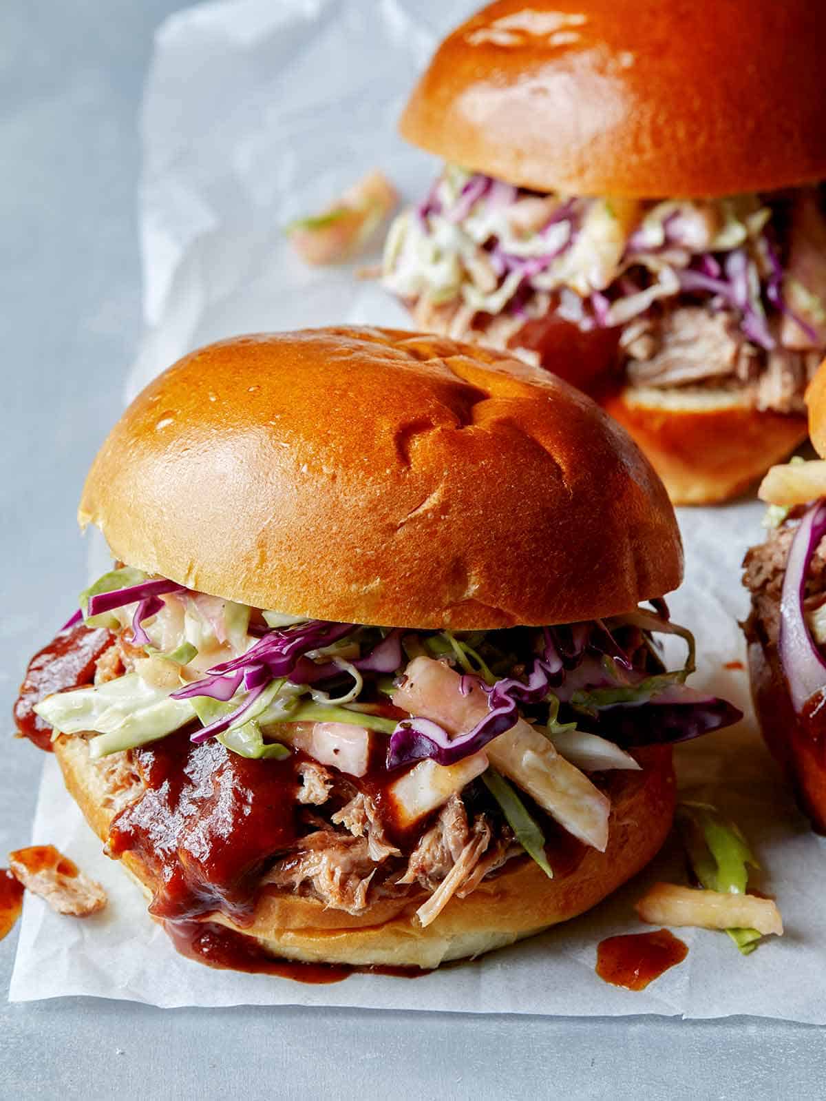 Slow Cooked Pulled Pork sandwiches on a surface. 