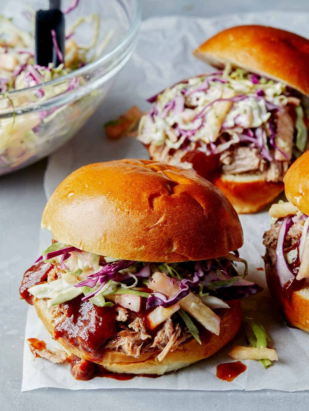 Pickled pulled pork sandwiches on a surface.
