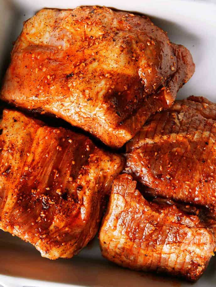 Pork butt in a container to make pulled pork.