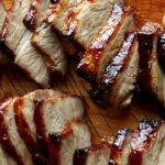 Char siu sliced on a cutting board.