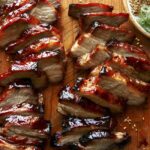 Char siu pork on a cutting board.