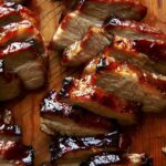 Char siu pork on a cutting board.