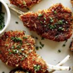 Close up on a platter of panko crusted lamb chops.