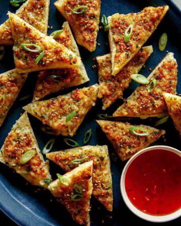 Shrimp toast recipe on a platter with a sweet chili dipping sauce.