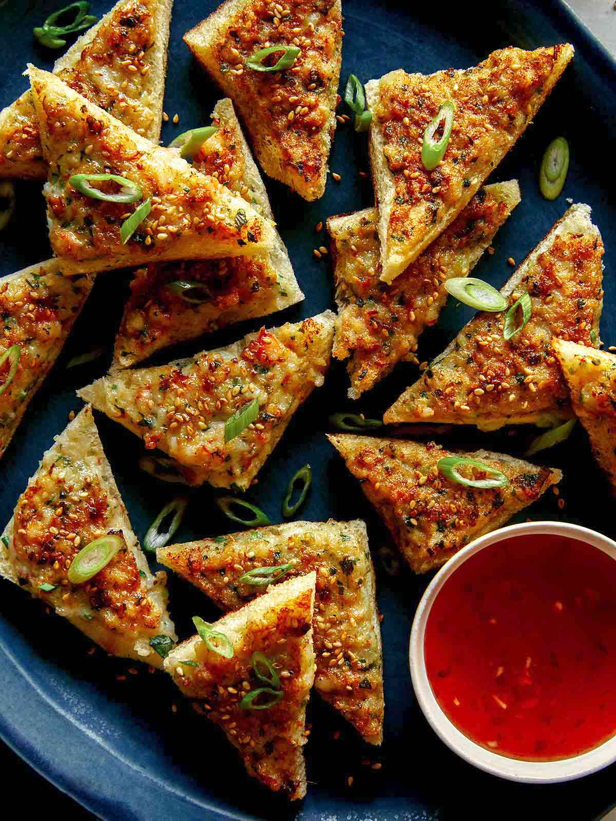 Shrimp toast recipe on a platter with a sweet chili dipping sauce. 