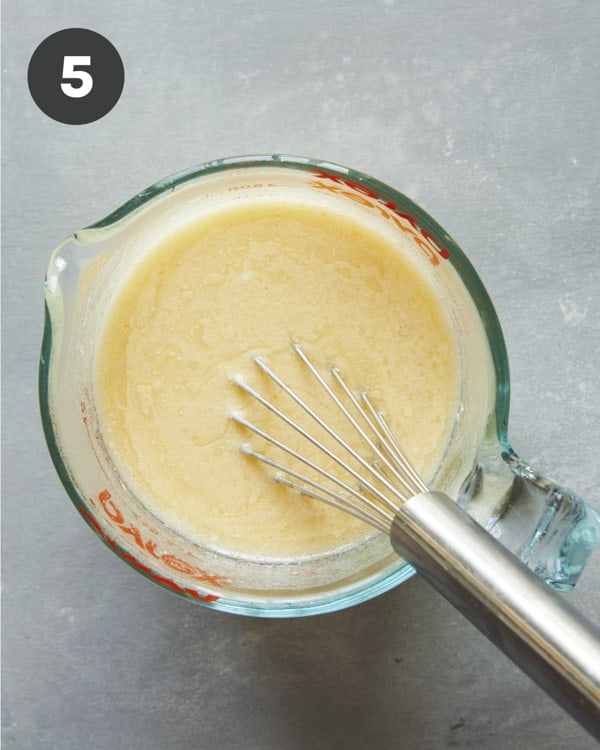 Wet ingredients in a measuring cup whisked together.