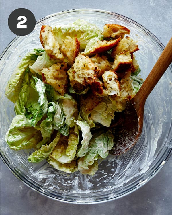 Caesar salad ingredients with homemade croutons on top.