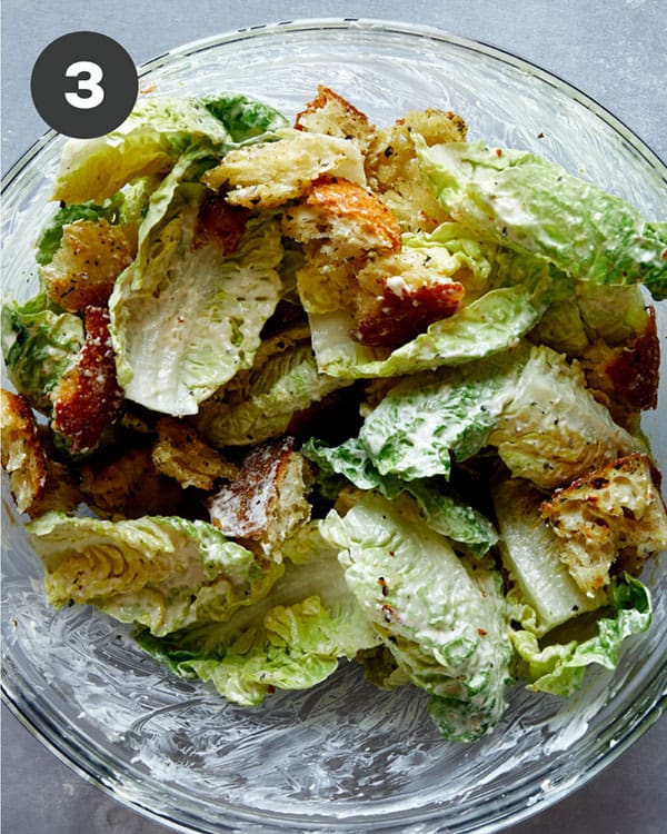 Caesar salad freshly mixed in a bowl.