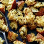 Homemade croutons recipe on a platter with a spoon.