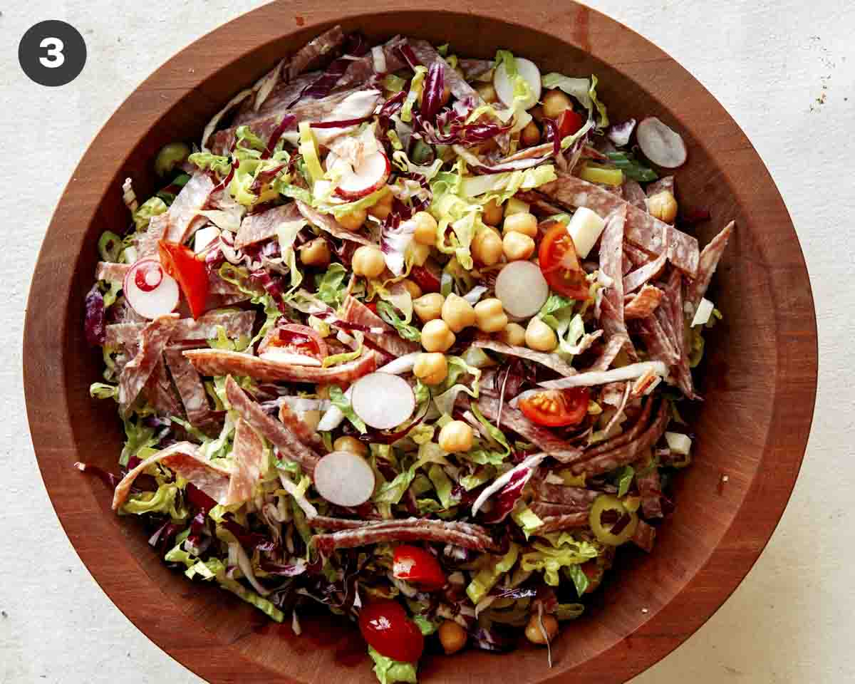 Italian chopped salad in a wood bowl tossed together. 