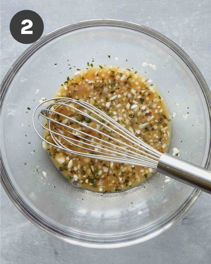 Red wine vinaigrette recipe in a bowl being whisked together. 