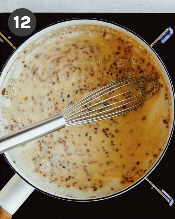 Flour being whisked into a pot to make a gravy. 