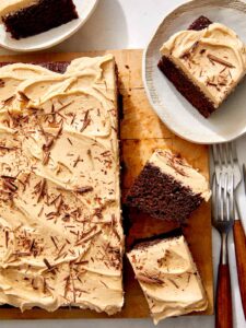 Chocolate sheet cake on a board with slices on the side.